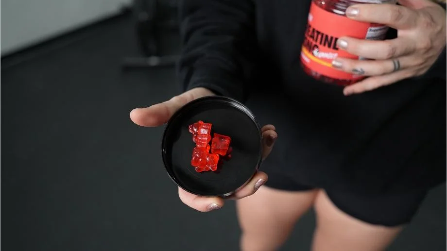 swoly-creatine-gummies-close-up-gummies-sitting-in-lid A person holds Swoly Creatine Gummies an upturned black lid.