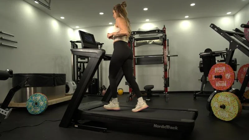 Side view of a person walking on the NordicTrack Commercial 1250 treadmill.