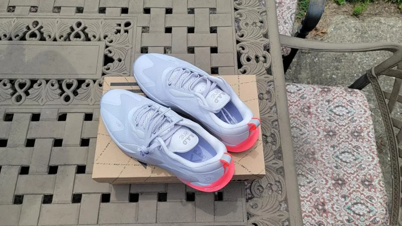 A pair of RAD One V2 training shoes perched on top of their shoebox