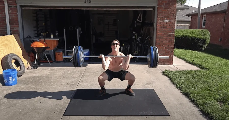 Man performing a clean on a rubber horse stall mat