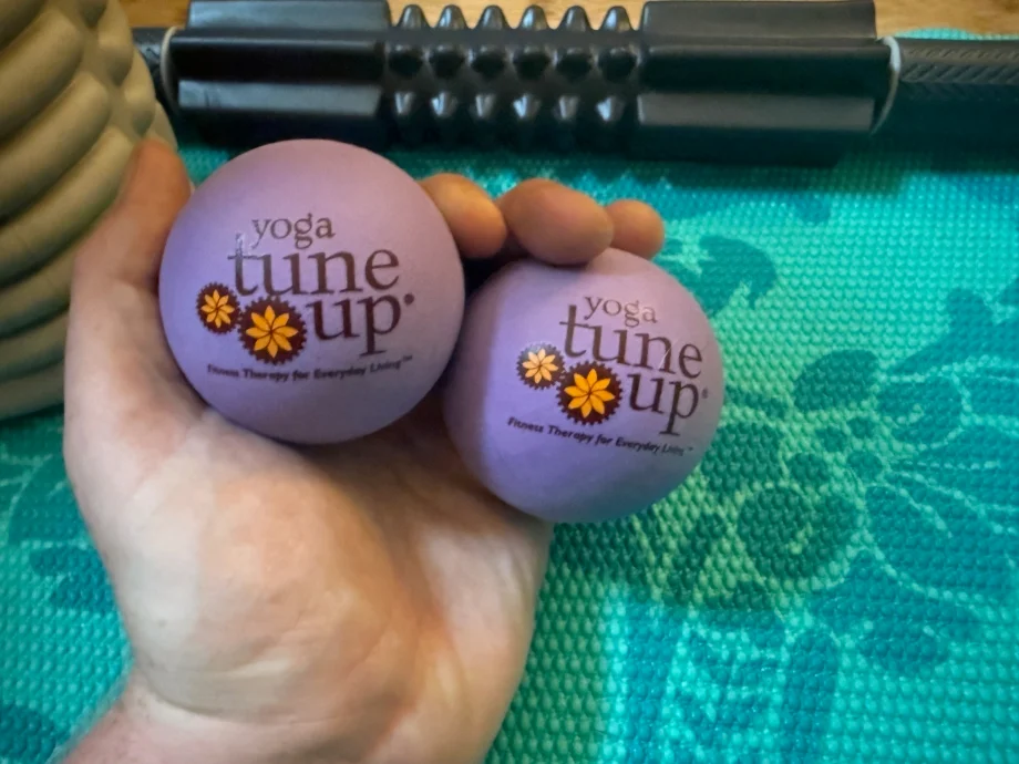 Our tester holding two Yoga Tune-up massage ball in one hand