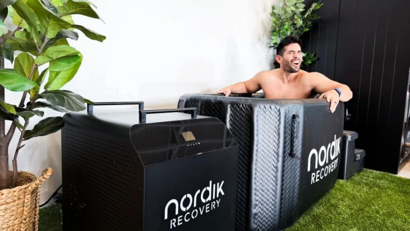 Man sitting in the Nordik Recovery cold plunge tub