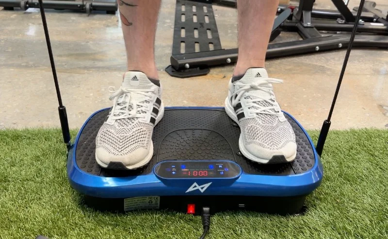 A person stands on an AXV Vibration Plate