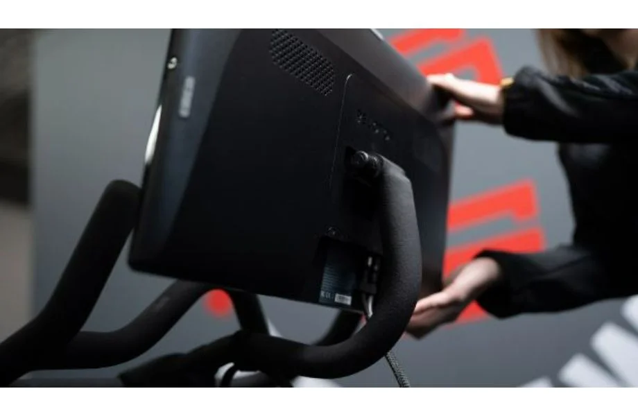 A person adjusts the Peloton Bike screen