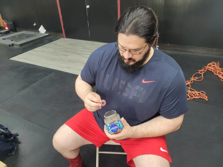 Olympian Caine Wilkes eating some Olly Pre-Game Energize Gummies