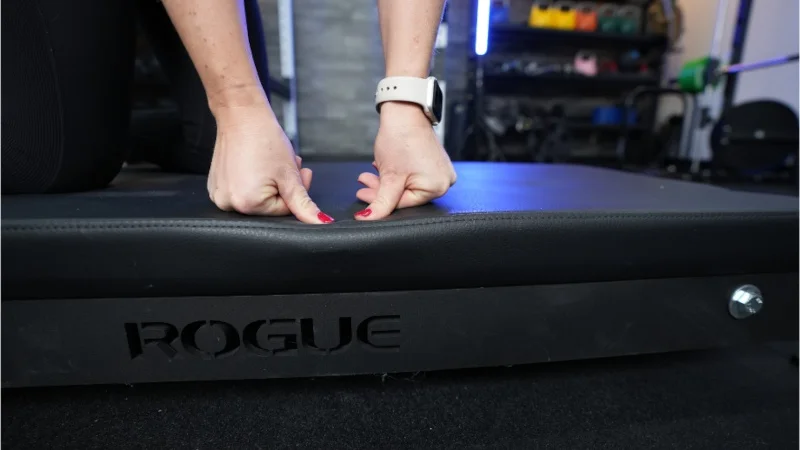Our tester leans into the cushion of the Rogue Floor Glute machine
