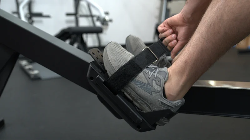 Our tester adjusting the foot cradles on the YOSUDA Air Magnetic Rowing Machine Pro