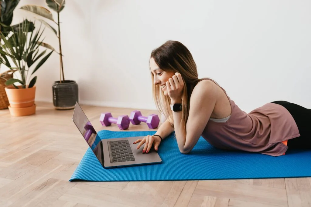 Woman with Computer on Yoga Mat Pexels min scaled 1