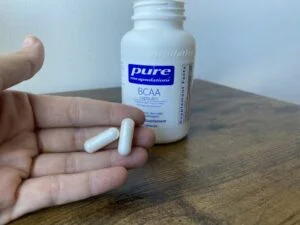 pure encapsulations bcaa capsules in hand