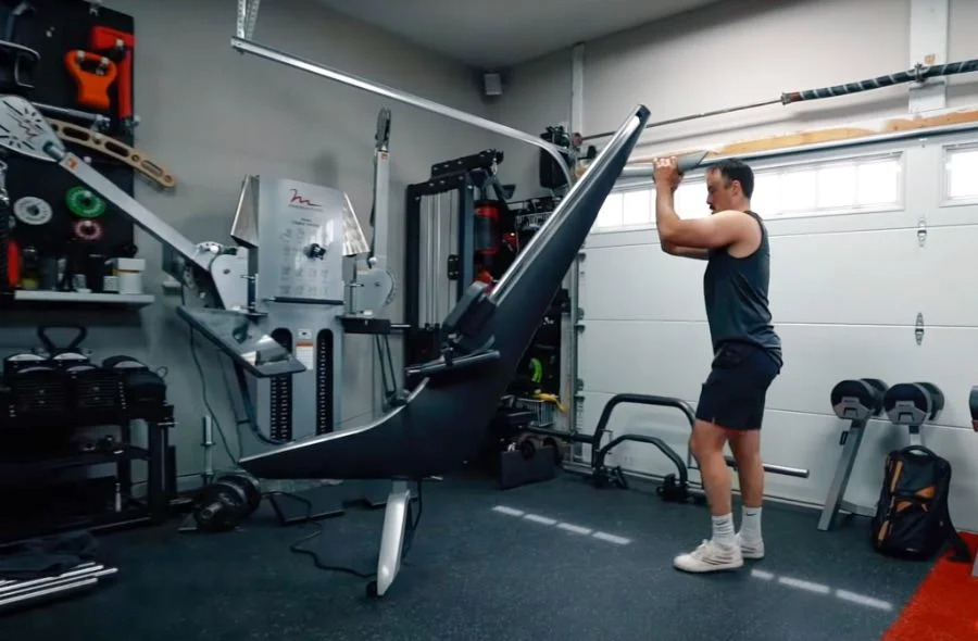Man moving the Hydrow Rower in a garage gym