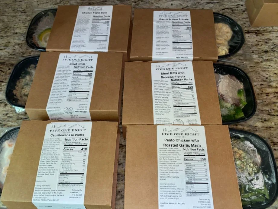 All of the meals are stacked up from inside a package from the 518 Kitchen meal delivery service