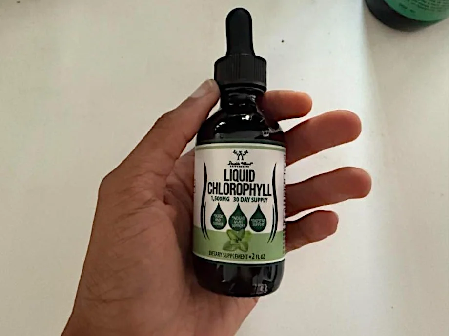 Our tester holds up a bottle of Double Wood Liquid Chlorophyll