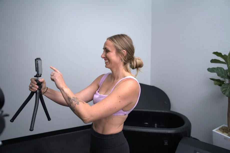 Lindsay smiles into a camera while standing in front of the Hydragun Supertub Cold Plunge.