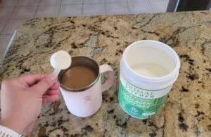 pouring primal kitchen collagen peptides into cup of coffee