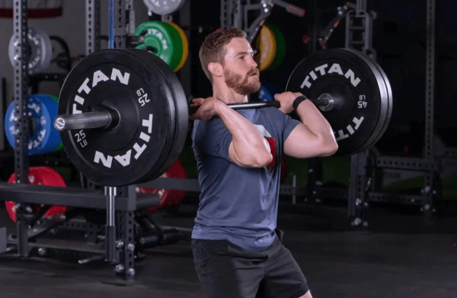 A man cleaning a barbell loaded with Titan Fitness Economy Bumper Plates
