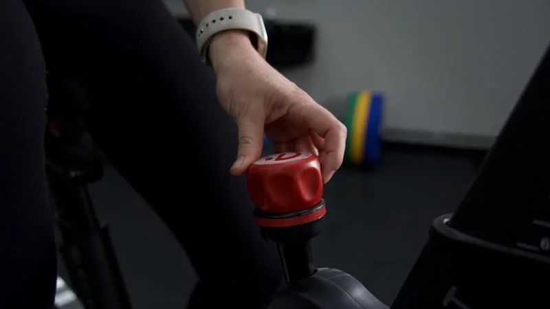 Our tester adjusting the red knob on an Echelon EX-5 exercise bike