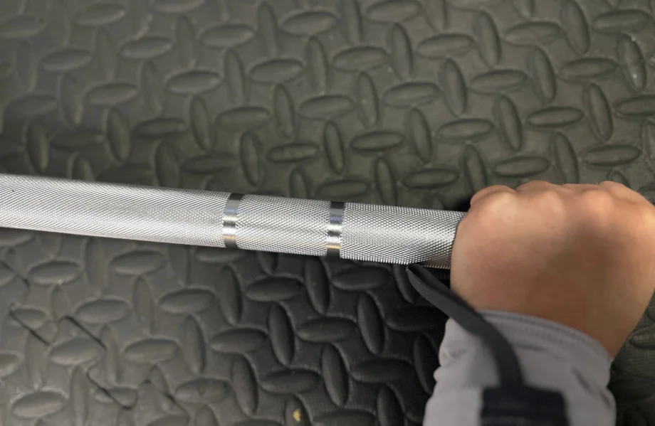 A person grabbing the Bells of Steel Olympic Barbell 2.0.