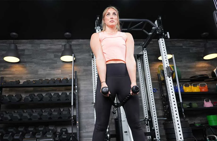Woman in the top position of a cable pull-through exercise