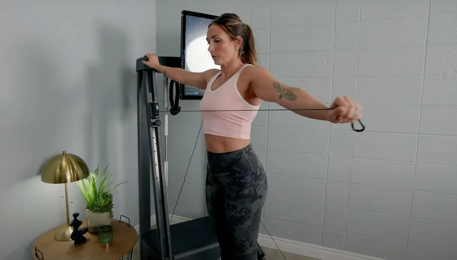 Lindsay Scheele, CPT extends an arm while doing a workout with the Echelon Strength Home.