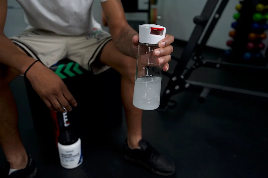 Product tester holding a water bottle mixed with Nutricost Creatine