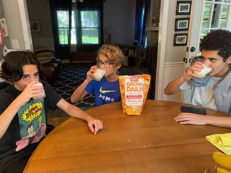 3 kids sit at a table drinking Grow Daily shakes