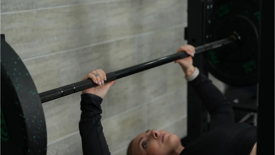 A person doing a bench press with the Major Fitness Barbell.