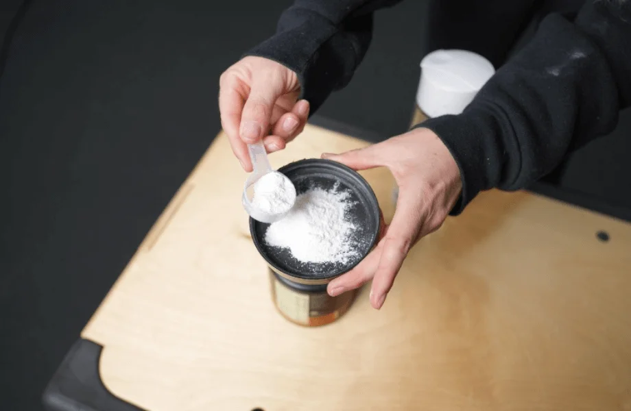 Our tester grabbing a scoop of Optimum Nutrition Gold Standard Pre-Workout