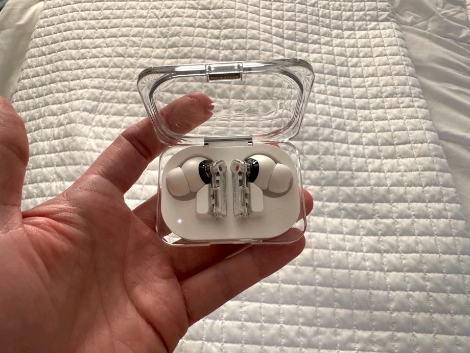 Our tester holds a pair of Nothing Ear (a) wireless earbuds in their charging case.