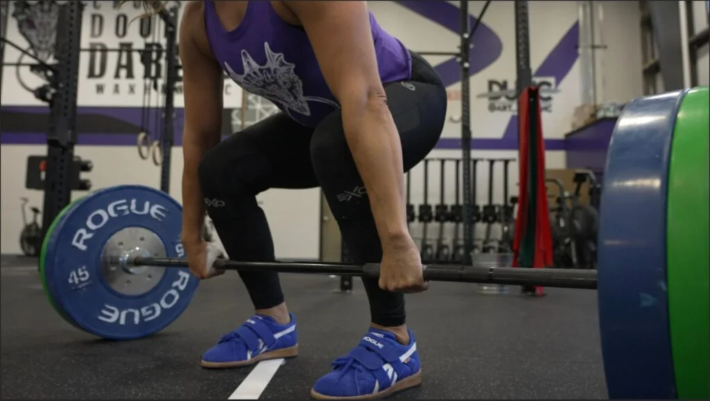Woman preparing to deadlift using the Rogue Bella Bar
