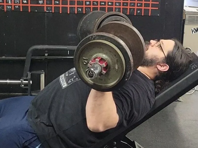 A man performing incline press with the Titan Loadable Dumbbells
