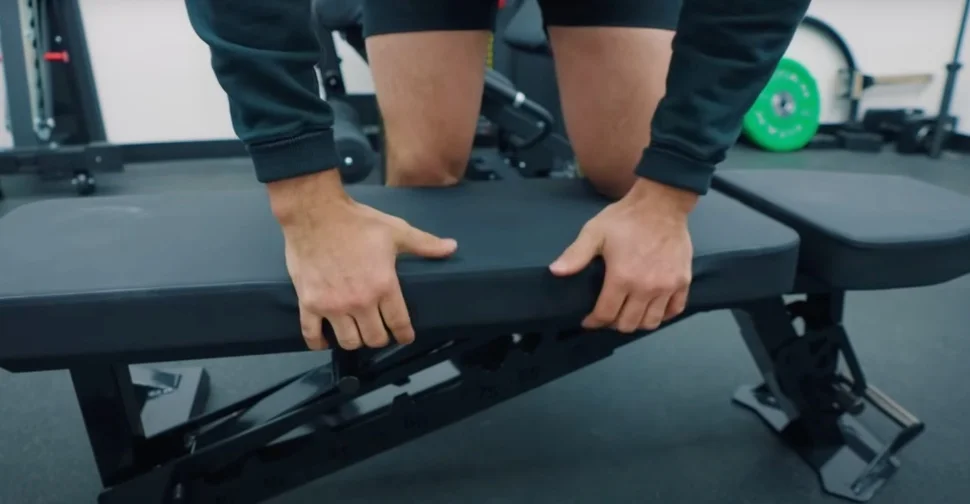 Coop Mitchell kneels on a REP Nighthawk weight bench to test the vinyl.