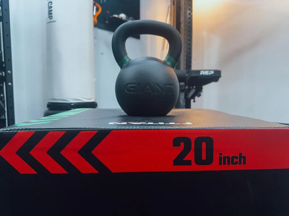 A Giant v3 24kg Kettlebell resting on a plyo box.