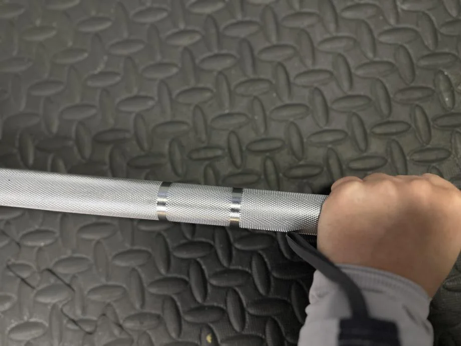 A hand grasps the knurling on a Bells of Steel Olympic weightlifting Bar 2.0
