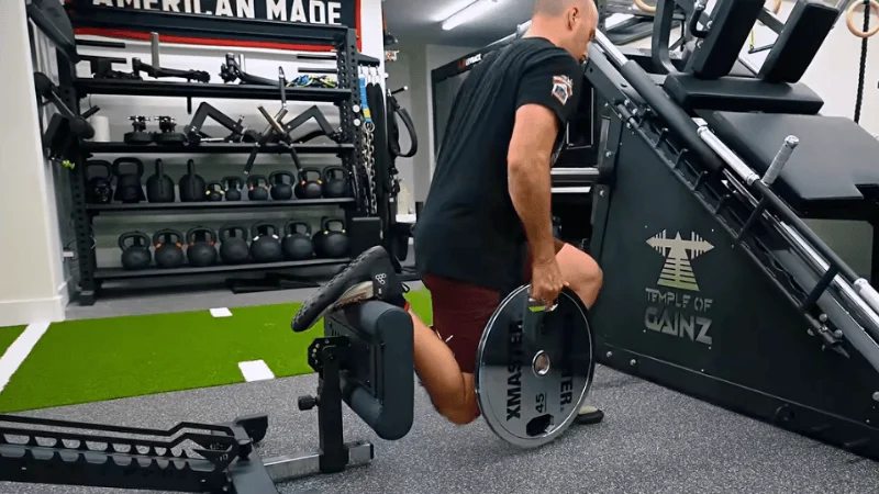 Our tester performing split squats on the Tib Bar Guy Apex Adjustable Bench