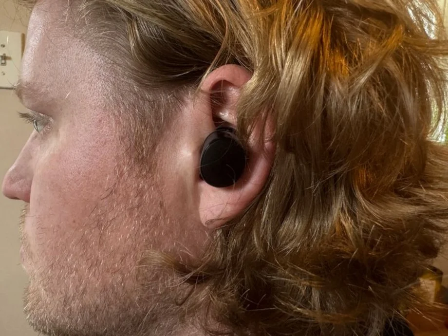 A person wearing Bose QuietComfort wireless earbuds