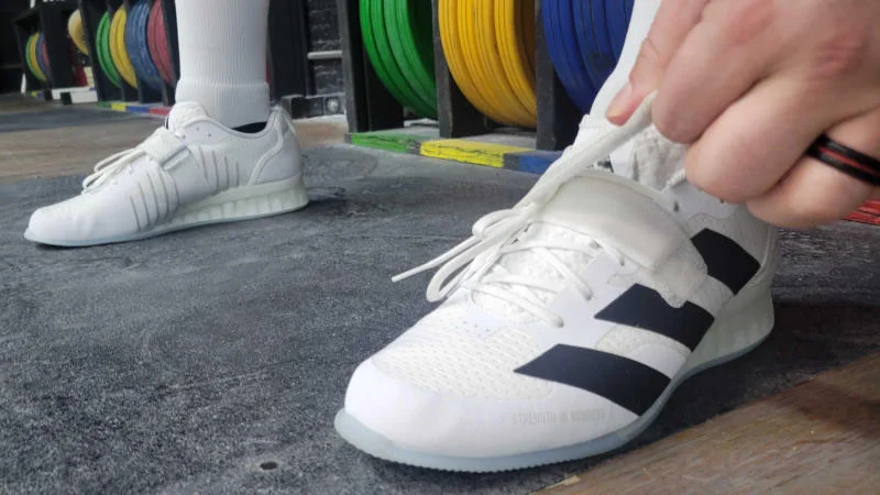 Our tester putting on a pair of adidas Adipower III weightlifting shoes
