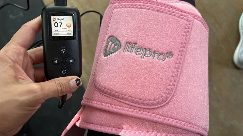 a-person-wearing-the-lifepro-allevared-light-therapy-belt-around-the-thigh A person wears a LifePro AllevaRed Light therapy Belt around their thigh.