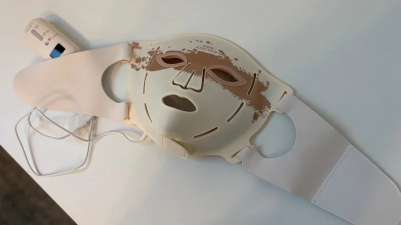 The Renpho LED Light Therapy Mask on a white table