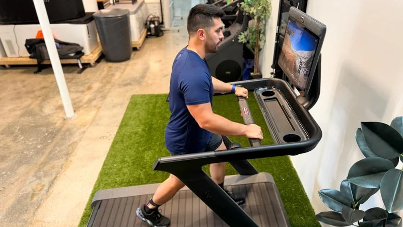 Side view of a person running on the Peloton Tread+ treadmill